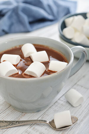 Mug with hot chocolate and marshmallows on wooden tableの写真素材