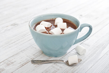 Mug with hot chocolate and marshmallows on wooden tableの写真素材