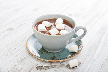 Mug with hot chocolate and marshmallows on wooden tableの写真素材
