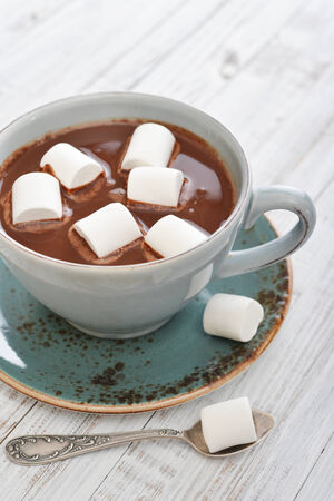 Mug with hot chocolate and marshmallows on wooden tableの写真素材