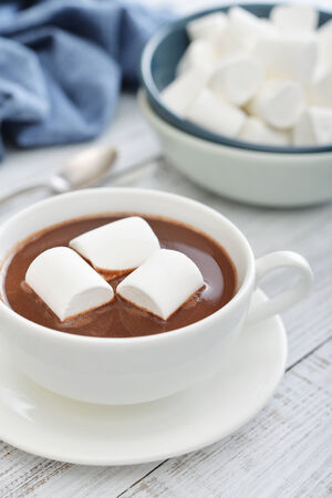 Mug with hot chocolate and marshmallows on wooden tableの写真素材