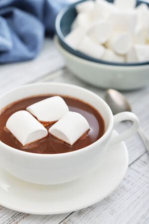 Mug with hot chocolate and marshmallows on wooden tableの写真素材