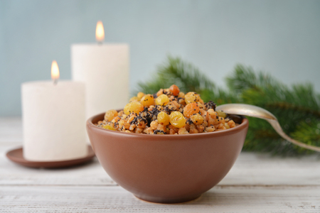 Traditional Christmas slavic dish kutia in ceramic bowl with spoon and candlesの写真素材