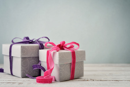 Gift boxes with violet and pink ribbons on blue background