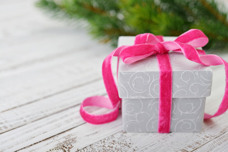 Gift box with ribbon and christmas decor on wooden backgroundの写真素材