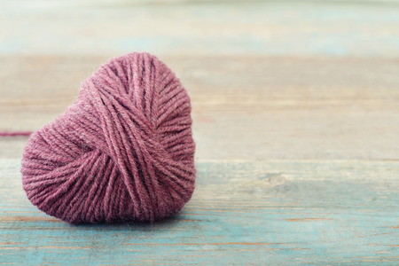 Pink clew in shape of heart on vintage wooden backgroundの写真素材