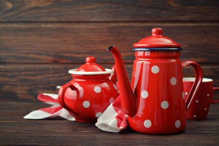 Two red vintage teapots with cup on wooden backgroundの写真素材