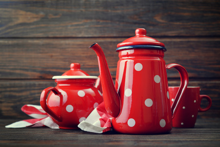 Two red vintage teapots with cup on wooden backgroundの写真素材