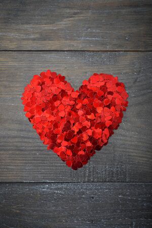 Confetti in shape of heart on wooden backgroundの写真素材