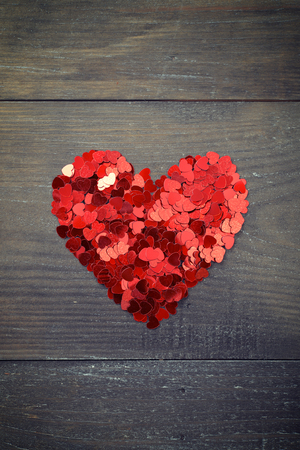 Confetti in shape of heart on wooden backgroundの写真素材