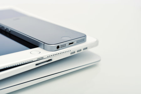 KIEV, UKRAINE - JANUARY 29, 2015: Pile of Apple iPhone 5s, iPad Air 2 and MacBook Air . Apple Inc. is an American multinational corporation that designs, develops, and sells consumer electronics.のeditorial素材