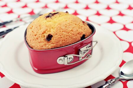 Freshly baked cranberry muffin in shape of heart.の写真素材