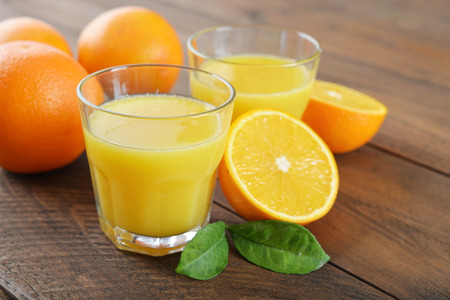 Orange juice in glass with  fresh fruits on wooden backgroundの写真素材