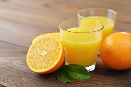 Orange juice in glass with  fresh fruits on wooden backgroundの写真素材