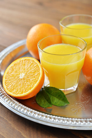 Orange juice in glass with  fresh fruits on wooden backgroundの写真素材