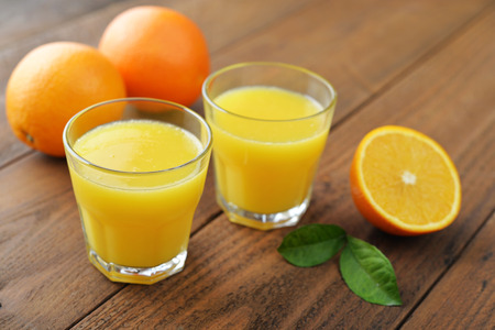Orange juice in glass with  fresh fruits on wooden backgroundの写真素材