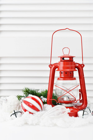 Christmas decorations with red vintage lantern and fir tree on white wooden backgroundの写真素材
