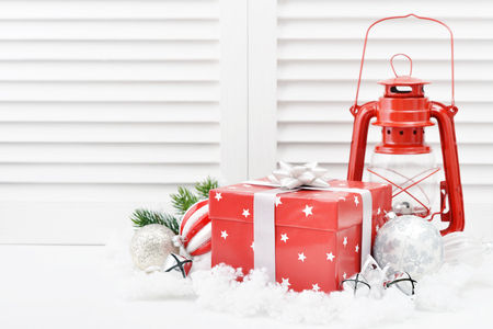 Christmas decorations with gift box, red vintage lantern and fir tree on white wooden backgroundの写真素材