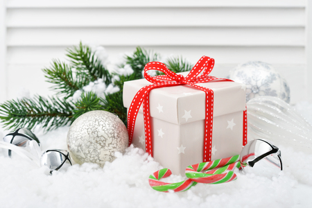 Gift box with christmas decorations and fir tree on white wooden backgroundの写真素材