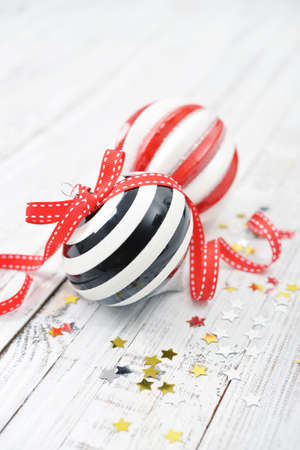 Two christmas striped balls with confetti on wooden backgroundの写真素材