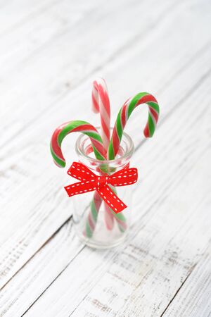 Christmas candy cane in glass jar on wooden backgroundの写真素材