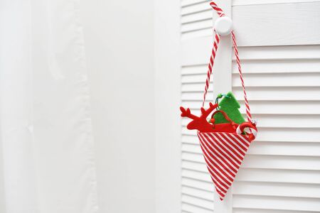 Christmas decorations in shape of fir tree, candy cane and a deer over white wooden backgroundの写真素材
