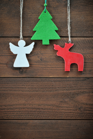 Christmas decorations in shape of fir tree, angel and a deer over wooden backgroundの写真素材