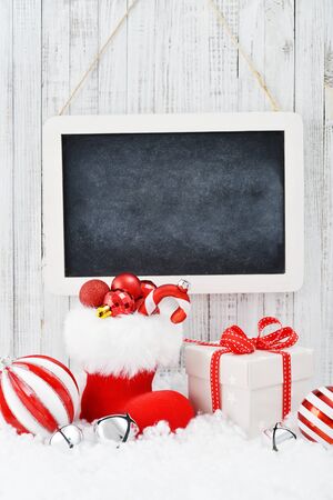 Slate board with Christmas decorations on light wooden backgroundの写真素材