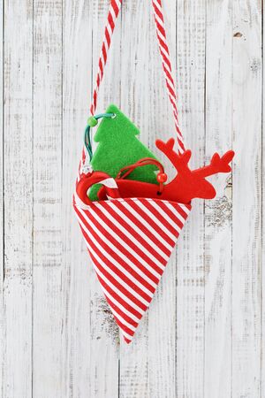 Christmas decorations in shape of fir tree, candy cane and a deer over wooden backgroundの写真素材