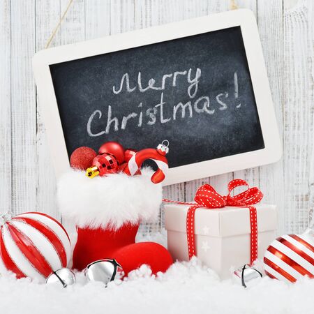 Slate board with Christmas decorations on light wooden backgroundの写真素材