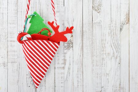 Christmas decorations in shape of fir tree, candy cane and a deer over wooden backgroundの写真素材