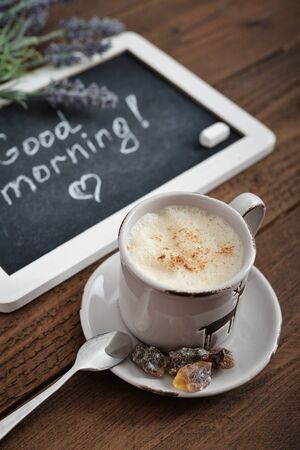 Cup of coffee with blackboard on wooden backgroundの写真素材