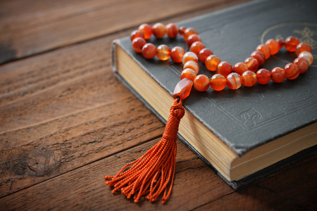 Holy Quran with beads over wooden background close upの写真素材