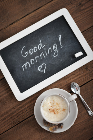 Cup of coffee with blackboard on wooden backgroundの写真素材