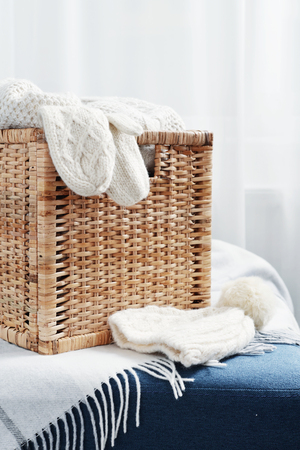 Rattan baskets with winter clothes and white mittens closeupの写真素材