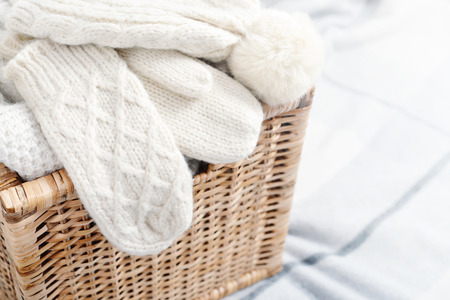 Rattan baskets with winter clothes and white mittens closeupの写真素材