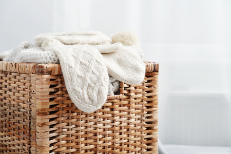 Rattan baskets with winter clothes and white mittens closeupの写真素材