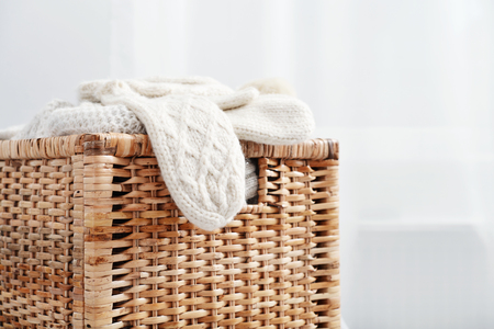 Rattan baskets with winter clothes and white mittens closeupの写真素材