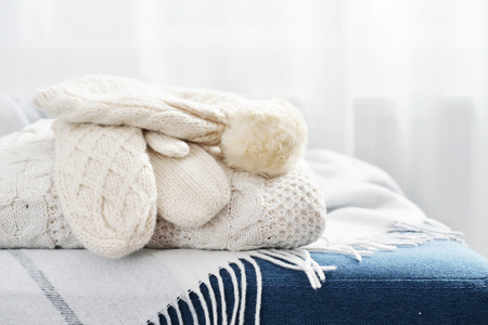 Stack of winter wear and accessorize closeup on couchの写真素材