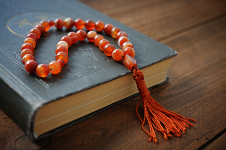 Holy Quran with beads over wooden background close upの写真素材