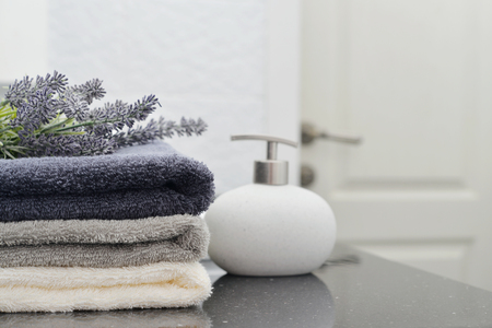 Stack of towels with a soap dispenser  in a bathroom closeupの写真素材