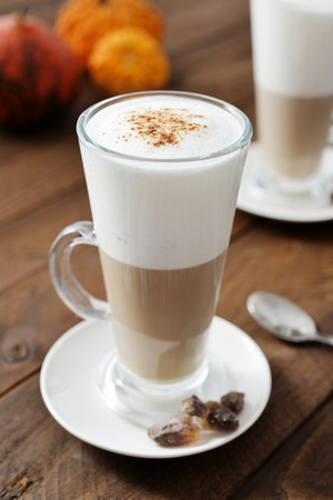 Pumpkin spice latte with cinnamon and decorative pumpkinsの写真素材