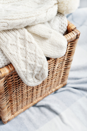 Rattan baskets with winter clothes and white mittens closeupの写真素材