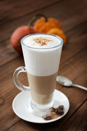 Pumpkin spice latte with cinnamon and decorative pumpkinsの写真素材