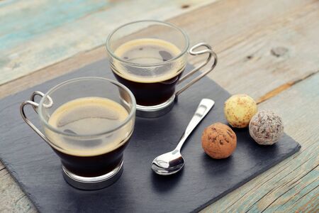 Two glass cups of coffee on slate trayの写真素材