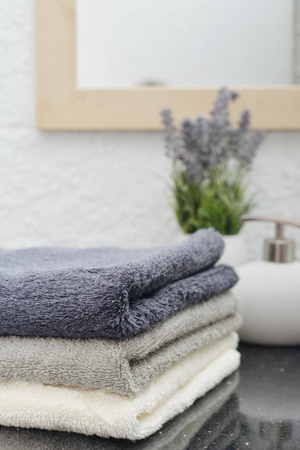Stack of towels with a  soap dispenser in a bathroom closeupの写真素材