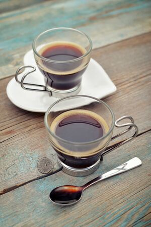 Two glass cups of coffee on wooden backgroundの写真素材
