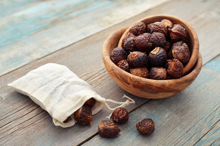 Soap nuts in bowl on wooden background closeupの写真素材