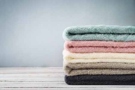 Stack of bath towels on light wooden background closeupの写真素材