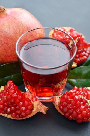 Pomegranate juice in glass and fresh fruits  on slate backgroundの写真素材